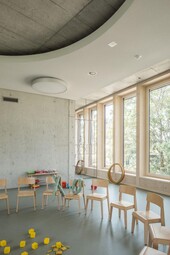 Innenansicht: Fassade in Holz. Darüber liegt die Betondecke