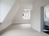 Plenty of light thanks to large windows: View into the attic apartment of the residential building