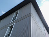 The elegant vertical profile of the wooden facade sets the scene for the building